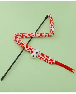 Dettaglio del giocattolo con nastro di serpente di peluche rosso e bianco con occhi buffi e bastoncino.