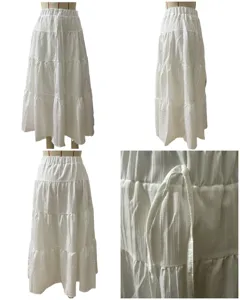 White tiered maxi skirt detail showing elastic waist, adjustable drawstring and textured fabric.