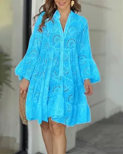 Charmante robe courte bleue lumineuse col V ample brodée ajourée avec manches évasées.