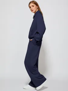 Detailed view of the elegant navy blue half-zip sweatshirt and wide-leg trousers outfit.