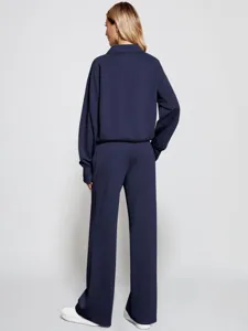 Detail view of the women's half zip sweatshirt and wide leg pants tracksuit in dark blue.