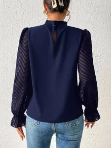 Achterkant detail van donkerblauwe blouse met opstaande kraag en gestructureerde mouwen.