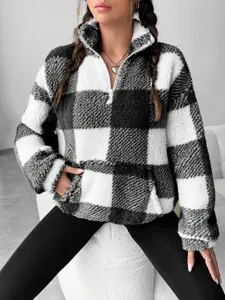 Close-up detail of black and white checkerboard sherpa pullover with half-zip collar.