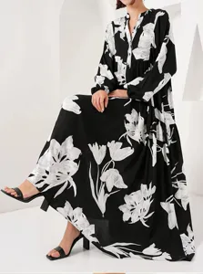 Elegant black long sleeve maxi dress featuring a striking white floral print detail view.