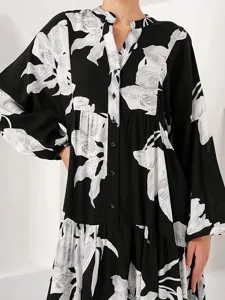 Detail view of a black and white floral print long sleeve dress with button-up collar design.