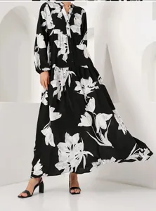Detail view of elegant black long sleeve maxi dress featuring white floral print and V-neck.