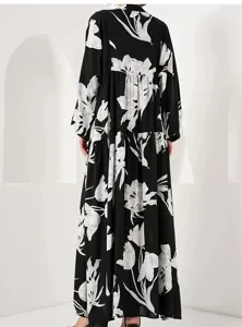Elegant black long sleeve maxi dress featuring a striking white floral print pattern.