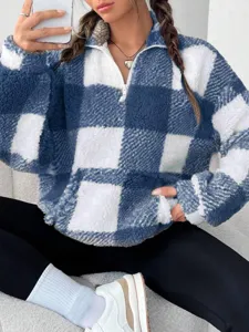 Detailed close-up shot of the blue and white checkered half-zip fleece sweatshirt.