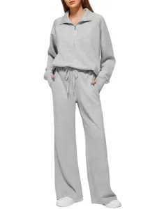 Close-up details of the grey half-zip sweatshirt and wide-leg sweatpants set texture.