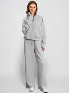 Detailed view of grey half-zip sweatshirt and wide-leg sweatpants set, soft texture and cuffs.