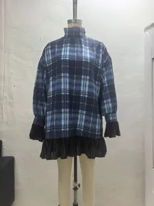 Blue plaid turtleneck dress detail showing black ruffle cuffs and hem for stylish daily wear.