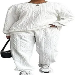 White cable knit two-piece loungewear set detail, featuring textured long sleeves and trousers.
