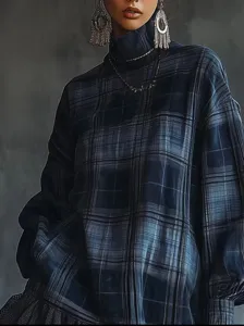 Close-up detail of stylish women's plaid turtleneck top with elegant ruffled hem design.