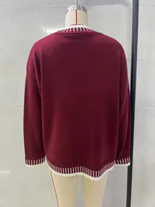Back view detail of red knit sweater showcasing contrast white striped hem and cuffs design.