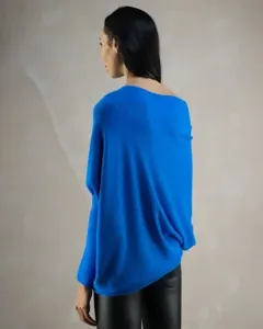 Vue détaillée d'un pull en tricot bleu vif avec des manches chauve-souris et un design plissé.