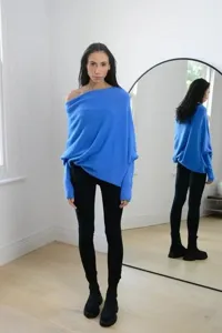 Vue détaillée du pull en tricot bleu, mettant en valeur sa texture douce et son drapé.