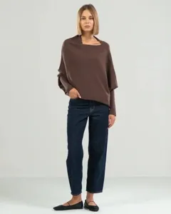 Vue détaillée du pull en tricot asymétrique marron pour femme avec jean bleu foncé.
