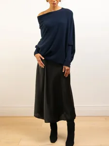 Gros plan sur les details de style du pull-over en tricot a manches longues bleu marine uni.
