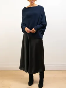 Vue détaillée d'un pull en tricot bleu marine à manches chauve-souris et jupe longue.
