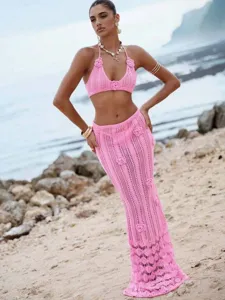 Detailed view of the pink crochet knit bikini and maxi skirt set featuring floral accents.
