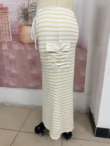 Side view of yellow and white striped knitted long skirt showing side cargo pocket detail.