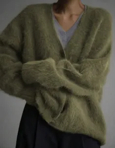 Detailed close-up shot of soft olive green faux mink cardigan, cozy loose knitwear texture.