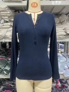 Detailopname van een effen geribbelde longsleeve henley-top in donkerblauw met knoopsluiting.