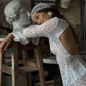 Detailed view of the backless white lace beach dress, elegant floral lace fabric texture.