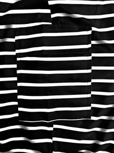 Black and white striped knit fabric close up detail showing pocket design for women clothing.