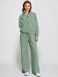 Detailed view of the sage green half-zip sweatshirt and wide-leg sweatpants casual set.