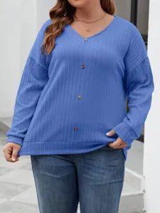 Detailed view of women's blue V-neck cable knit sweater featuring chic button decoration.