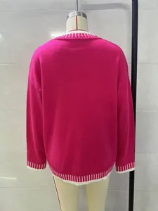 Detail view of the back of a hot pink knit sweater with white ribbed hem and cuffs.