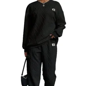 Women black ribbed knit sweater and long pants tracksuit set for autumn winter fashion outfit.