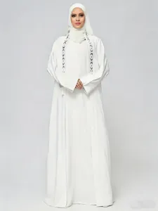 Detailed view of the white long sleeve embroidered outer coat and matching hijab set features fine work.