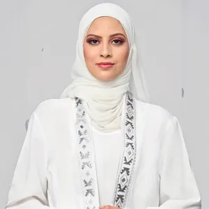 Women's white abaya dress set with matching hijab and elegant embroidered long sleeve outer robe.