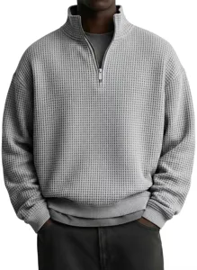 Detalle en primer plano de la sudadera gris de punto gofrado con cremallera de cuarto