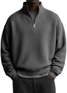 Sudadera gris oscura de punto waffle con media cremallera, cuello alzado y detalle texturizado.