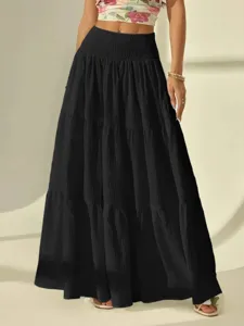 Detailed view of the black tiered maxi skirt, featuring textured fabric and elastic waist.