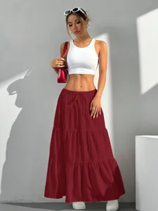 Casual tiered maxi skirt with drawstring waist, styled with white tank top and red bag.