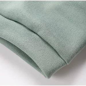 Close-up fabric detail of light green fleece sweatshirt, showing soft and clear texture.