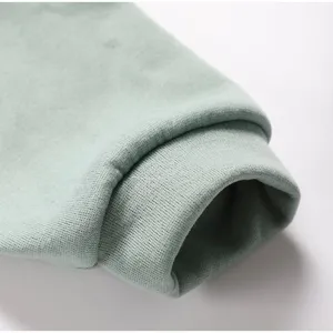 Detail shot of women's casual fleece hoodie sleeve cuff in sage green, soft and warm texture.