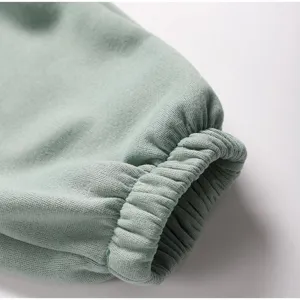 Mint green fleece sweatpants sweatshirt ribbed cuff detail close-up view comfortable fabric.
