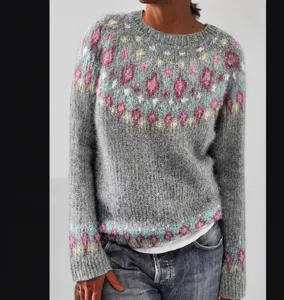 Detailed view of women's grey crewneck patterned knit sweater with colorful diamond design.