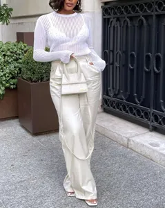 Gros plan détaillé du haut à manches longues transparent en tricot côtelé blanc pour femmes.