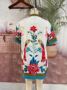 Detailansicht der kurzärmeligen Bluse mit tropischem Print, lebendiges Vogel- und Blumenmuster.