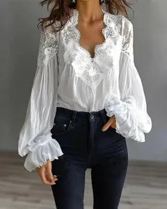 Gedetailleerd overzicht van witte kantpanelen en geplooide ballonmouwen van elegante top.