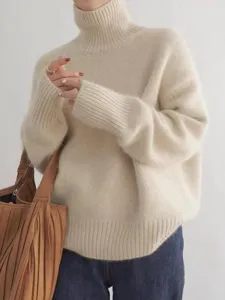 Vue détaillée du pull-over en tricot ample à col montant pour femme, texture douce.
