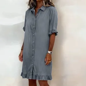 Gray denim shirt dress detail, featuring short lettuce-edge sleeves and a ruffled hem.