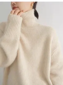 Gros plan sur le pull à col roulé douillet, mettant en valeur le col côtelé doux et la texture.