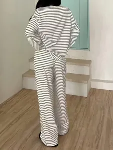 Detailed view of women's casual striped long sleeve top and high waist long pants outfit set.